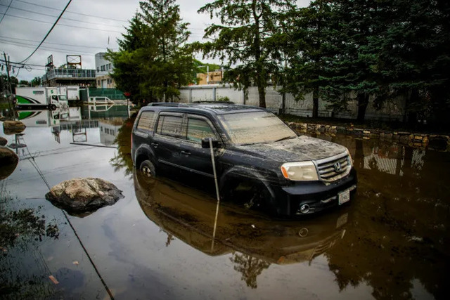 A car is partially submerged on the street in the Elmsford area
