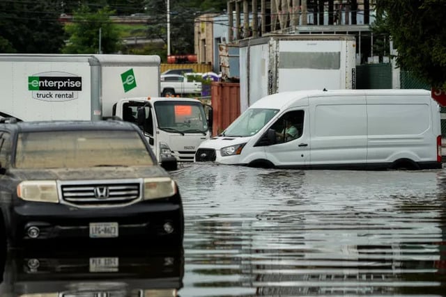 A van drives through a flooded street in the Elmsford area