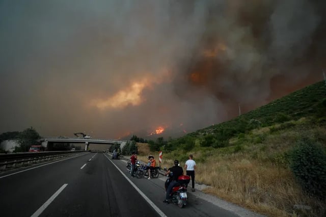 Smoke and flames rise among trees after a forest fire in Bilecik,Turkey on Wednesday